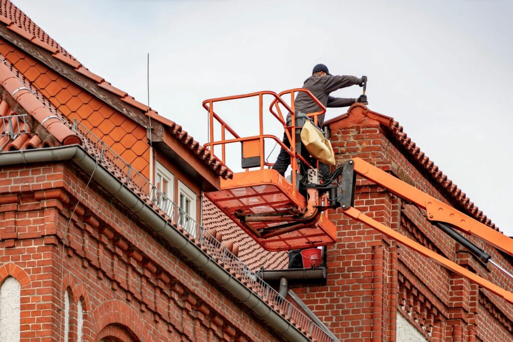 Takläggare monterar takpannor på en villa. Arbetet kräver kunskap om både material och byggfysik.